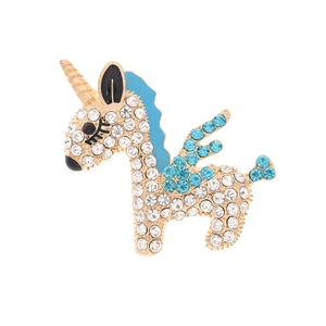 Detailed view of unicorn jewelry with blue and white crystals on a gold base