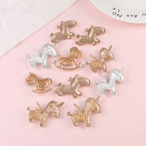 Macro view of gold and silver zebra and unicorn metal charms for DIY craft making