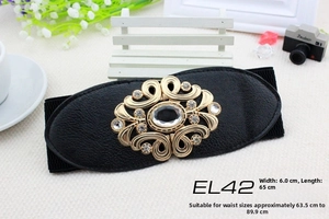 Detail of black elastic wide belt with golden rhinestone vintage buckle and lychee leather