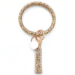 Detail of sunflower leopard print PU leather bracelet keychain with gold tassel and ring