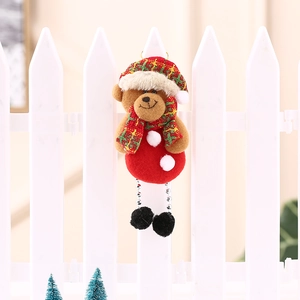 Dettaglio dell'orso di Natale in peluche con cappello a quadri su decoro di staccionata