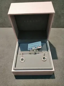 Close-up of S925 silver sunflower earrings and ring set in a pink velvet jewelry box