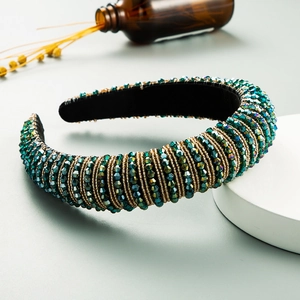 Detailed shot of emerald green crystal headband with gold chains and velvet lining