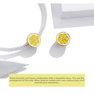 Detail of silver popcorn chain bracelet featuring a yellow enamel flower charm with zircon