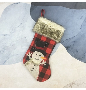 Detail of red buffalo plaid Christmas stocking with plush cuff and snowman embroidery