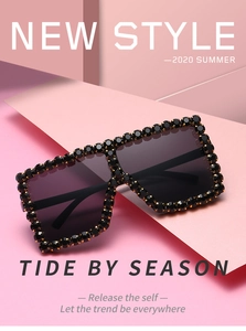 Macro shot of stylish square sunglasses with black and gold rhinestones on dark frames