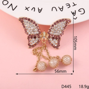 Golden butterfly pendant with purple rhinestones and pearl tassels measuring 105mm