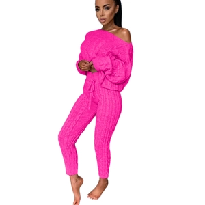 Dettaglio del set in maglia rosa acceso con maglione a spalle scoperte e pantaloni