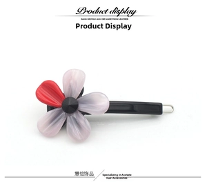 Détail de barrette à fleur en acétate avec pétales roses et centre en cristal noir