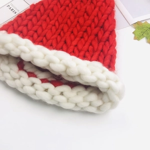 Close-up of thick red and white knitted yarn texture on a long tail Christmas hat