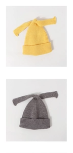 Detail showing the soft knit texture and long bunny ear bows on yellow and grey baby hats