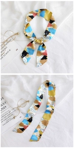 Chic skinny silk scarf with bear and cloud patterns tied on a vintage book with glasses