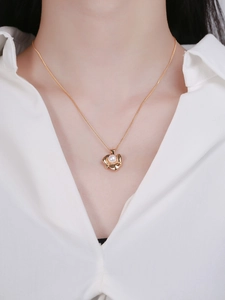 Detailed view of an elegant S925 silver gold floral pendant featuring a white pearl on model