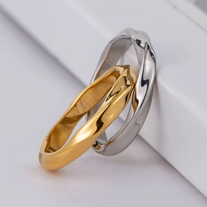 Minimalist interlocked gold and silver stainless steel rings with irregular wave texture