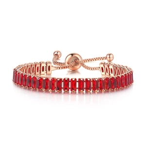 Detail of rose gold bolo bracelet featuring red baguette-cut crystals and adjustable slider