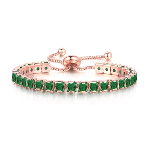 Detail of rose gold tennis bracelet featuring square green crystals and adjustable slider