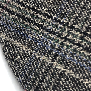 Macro view of multi-color tweed fabric texture on a stylish plaid beret hat for women