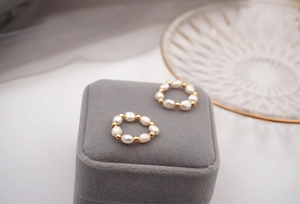 Macro detail of baroque freshwater pearls and gold beads on a vintage elastic ring