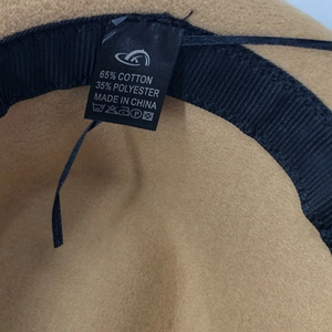 Detailed close-up of inner sweatband and fabric care label on a camel wool jazz hat