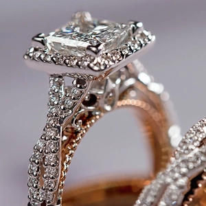 Detailed macro view of square cut diamond halo ring with rose gold engraving