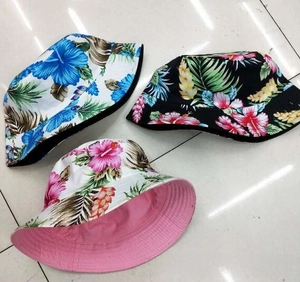 Detailed close-up of reversible tropical floral print bucket hats in three vibrant colors