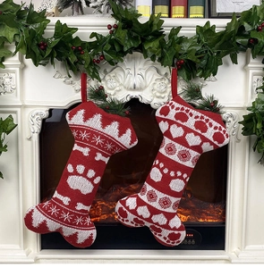 Detail of red and white knitted Christmas bone stockings with snowflake and dog paw patterns