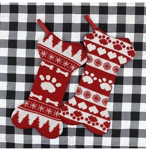 Detail of red and white bone-shaped Christmas stockings with dog motifs on plaid background
