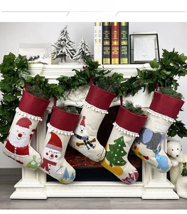 Detail of five assorted Christmas stockings with plush cuffs on a festive fireplace mantle