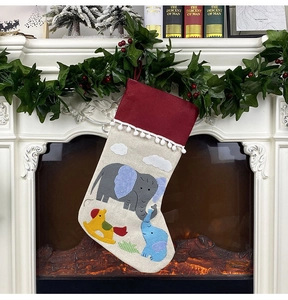 Detail of Christmas stocking with cartoon elephant patch hung by a festive fireplace