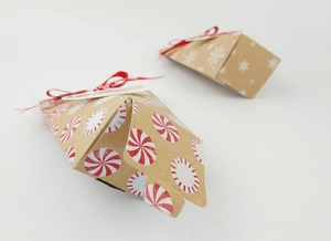 Détail de boîtes cadeaux de Noël en papier kraft avec flocons et rubans rouges