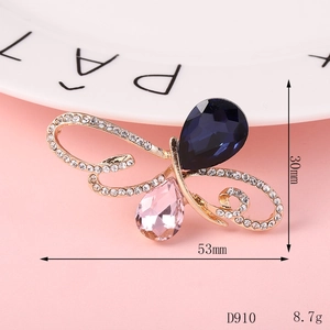 Detail of a butterfly brooch with blue and pink gemstones and sparkling white crystals