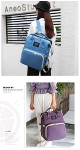 Detail of blue and purple large capacity diaper bags with reinforced straps and front pocket