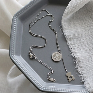 Macro detail of silver bear pendant with your heart belongs to me engraving on a chain