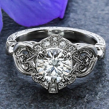 Macro shot of retro men's ring with round green zircon on gray stone background