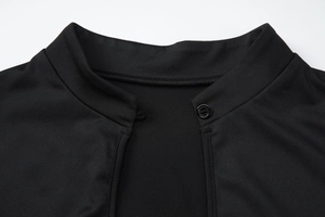 Détail du col montant noir avec fermeture à bouton unique et coutures de haute précision