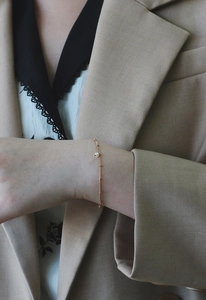 Close-up of minimalist 18K gold plated titanium bracelet with a small freshwater pearl
