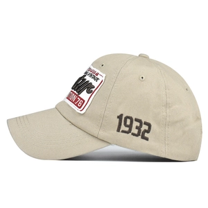 Gros plan de la casquette beige en coton avec broderie 3D 1932 et écusson vintage