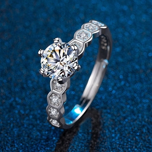 Macro shot of silver six-prong wedding ring with hexagonal honeycomb pavé side stones