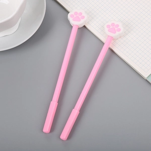 Niedliches Set rosa Katzenpfoten-Gelschreiber für Schüler auf einem Schreibtisch
