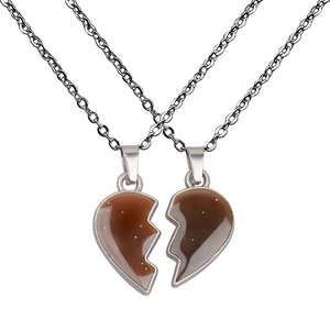 Detail of couple's heart puzzle necklace with sparkling green glitter and silver chain