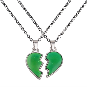 Close-up of heart-shaped magnetic necklaces with green color-changing wing pendants