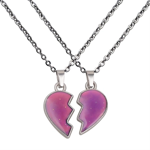 Macro detail of color-changing heart wing necklaces on silver stainless steel chains