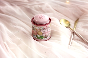 Detailed view of pink Bunny Lulu tin canister with vintage bunny illustration on soft tulle