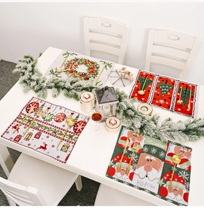 Flat lay of four knitted Christmas placemats with festive patterns and gold cutlery