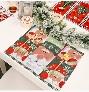 Close-up of a festive knitted Christmas placemat with Santa Claus motif and Feliz Navidad text