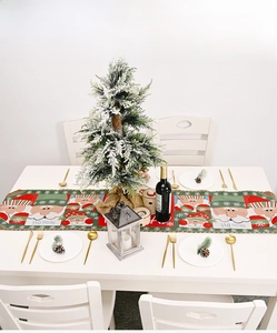 Detail of Christmas table runner with Santa Claus motifs and festive knit fabric texture