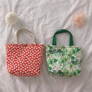 Detailed view of floral and tropical print canvas tote bags with metal button closures