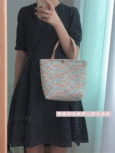 Detail of floral canvas lunch bag with pink handles and secure metal magnetic closure