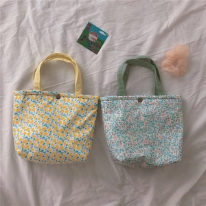 Detail view of floral and lemon print canvas bags with vintage metal snap closures