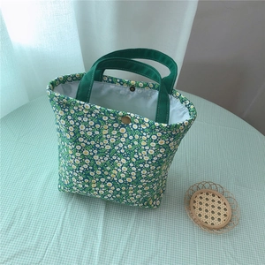 Detail of floral lunch bag with green daisy print and vintage golden metal snap button